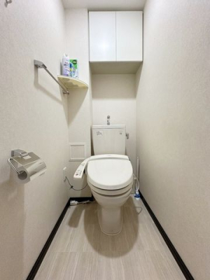 トイレ 温水便座付きトイレの様子。壁面に棚がございますのですっきり収納させることができます。